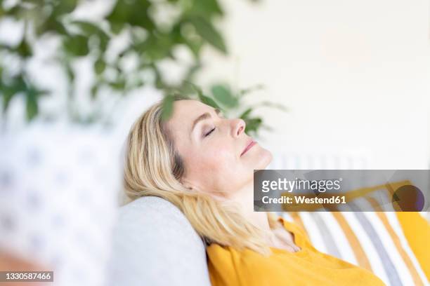 woman with eyes closed relaxing at home - napping stock pictures, royalty-free photos & images