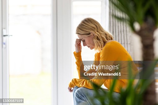 Depressed mature woman sitting at home Depressed mature woman sitting at home