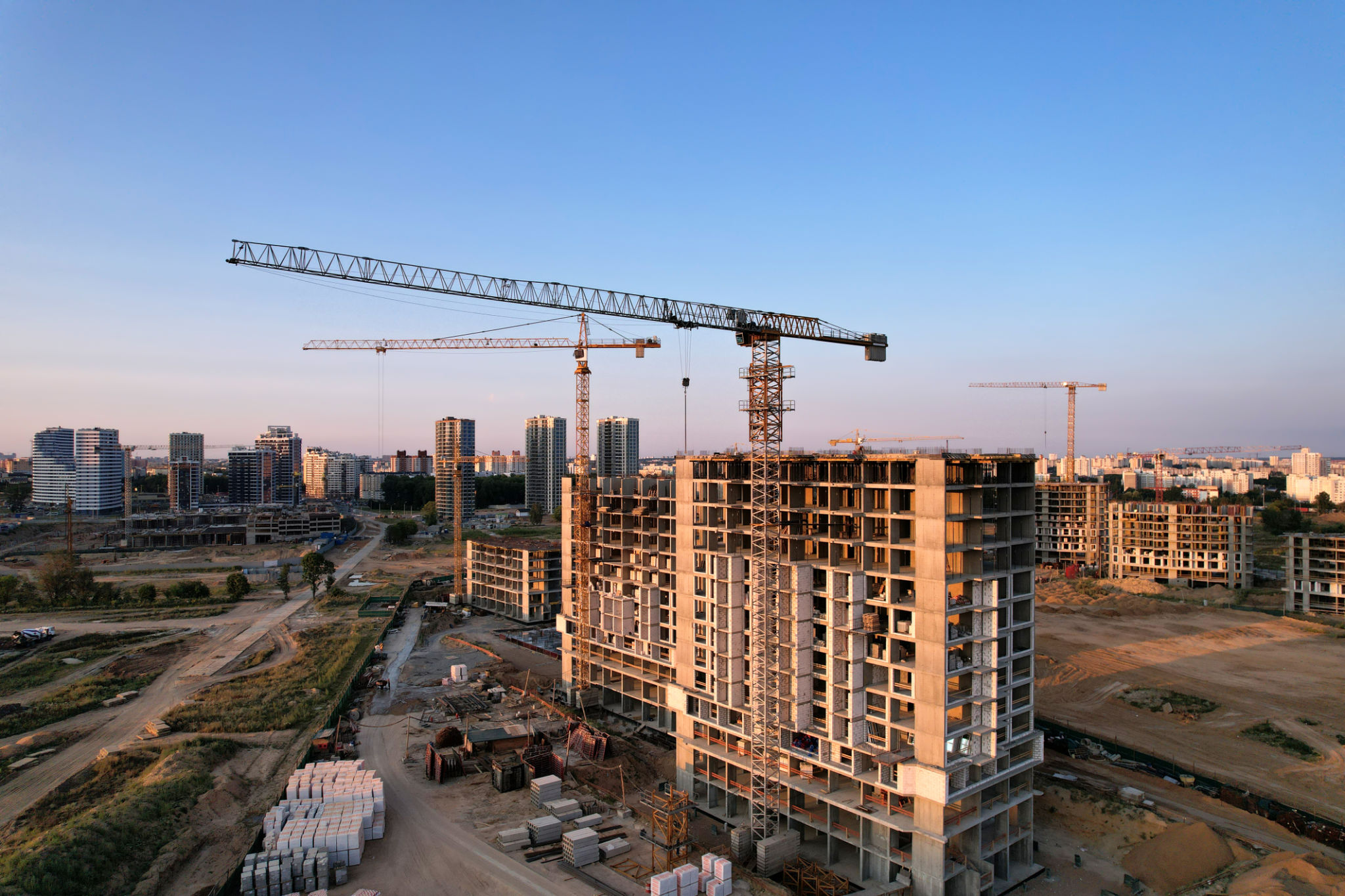 Tower crane on construction site on sunset background Tower crane on construction site on sunset background