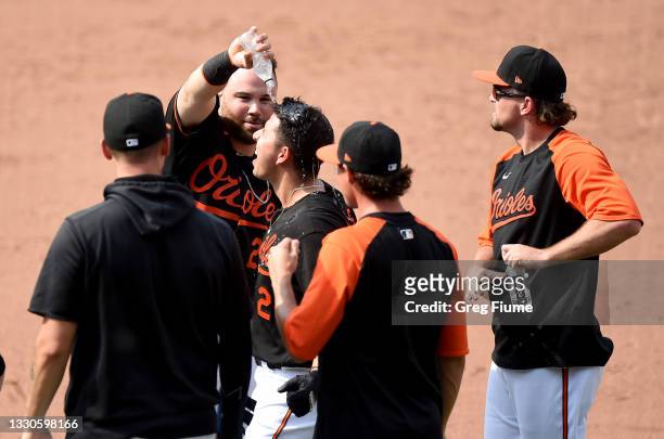 Ramon Urias of the Baltimore Orioles celebrates with teammates after driving in the game winning run in the ninth inning against the Washington...