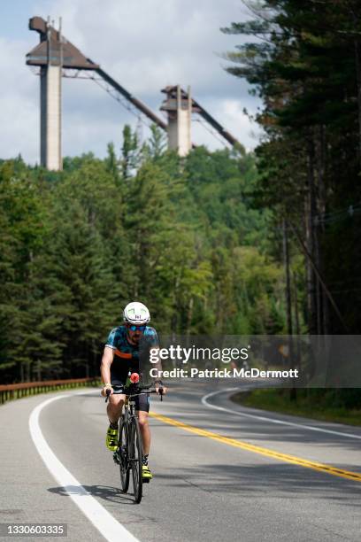 An athlete cycles past the ski jump used in the 1980 Winter Olympics during the cycling portion of the ViewSport IRONMAN Lake Placid on July 25, 2021...