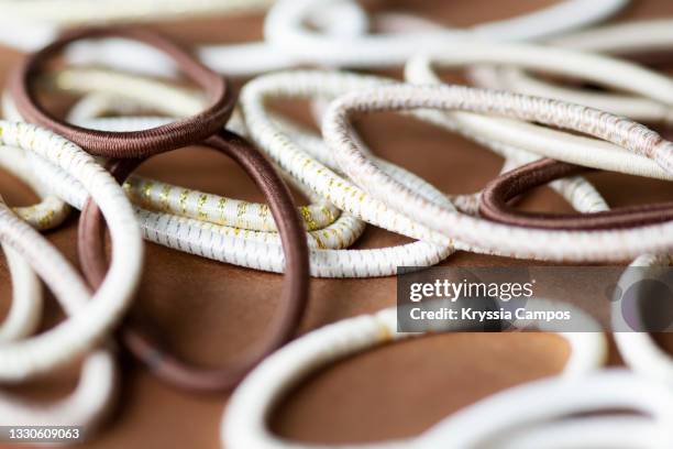 hair elastics on brown background - elastiekje stockfoto's en -beelden