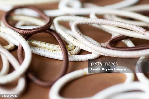 hair elastics on brown background - hair band stock pictures, royalty-free photos & images