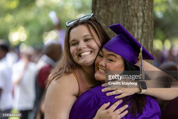 beste freunde umarmen sich, als einer die high school abt - high school graduation stock-fotos und bilder
