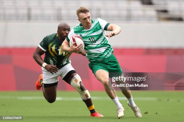 Terry Kennedy of Team Ireland runs with the ball in front of Siviwe Soyizwapi of Team South Africa on day three of the Tokyo 2020 Olympic Games at...