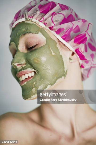 young asian woman making a clay mask on her face in the bathroom. - clay foto e immagini stock