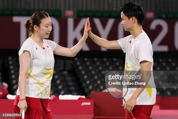 Yuta Watanabe and Arisa Higashino of Team Japan react as they compete against Praveen Jordan and Melati Daeva Oktavianti of Team Indonesia during a...