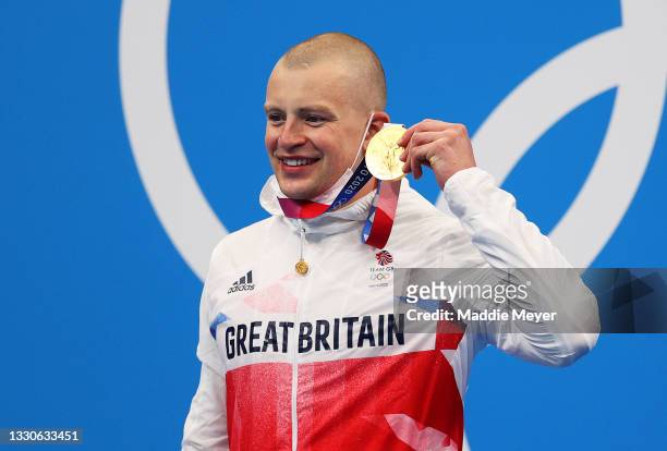 Adam Peaty of Team Great Britain poses with the gold medal for the Men's 100m Breaststroke Final on day three of the Tokyo 2020 Olympic Games at...