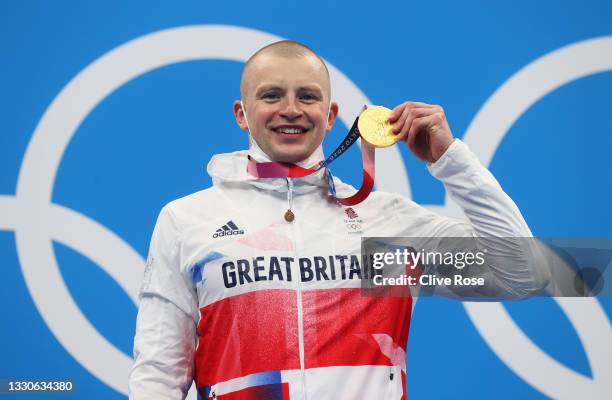 Adam Peaty of Team Great Britain poses with the gold medal for the Men's 100m Breaststroke Final on day three of the Tokyo 2020 Olympic Games at...