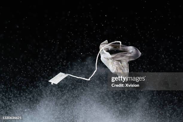 tea bag jump to mid-air on a white powder background with high speed creativity - powder tea stock pictures, royalty-free photos & images