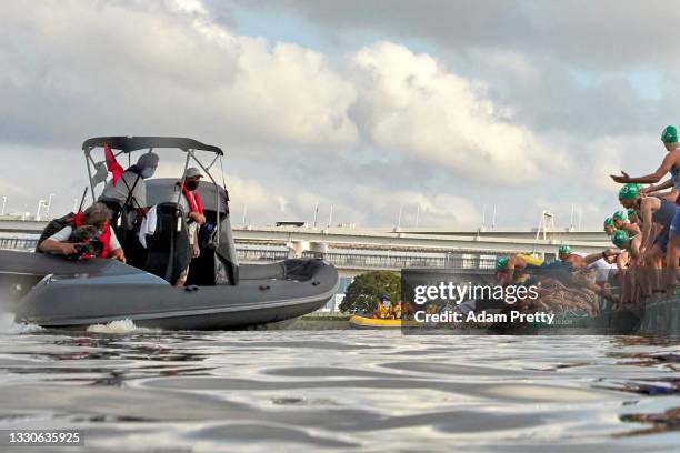 Triathletes dive into the water as a broadcast boat prevents all swimmers from starting forcing a restart before the Men's Individual Triathlon on...