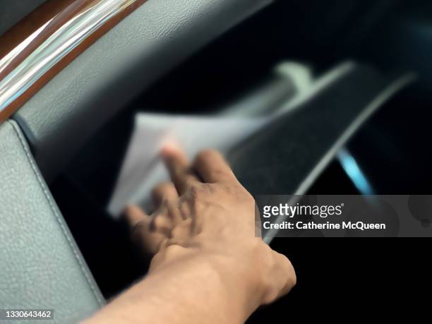 black woman reaches into car glove compartment - glove box stock pictures, royalty-free photos & images