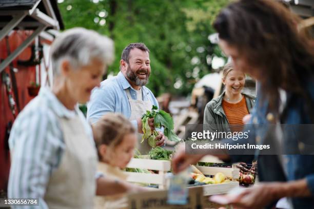 people selling and buying organic vegetables on farmers market. - mercado de productos de granja fotografías e imágenes de stock