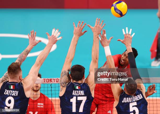 Wilfredo Leon Venero of Team Poland attempts to hit past the Team Italy defense during the Men's Preliminary Round - Pool A volleyball on day three...