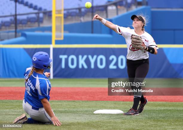Kelsey Harshman of Team Canada throws to first base to finish the double play as Emily Patricia Carosone of Team Italy starts her slide into second...