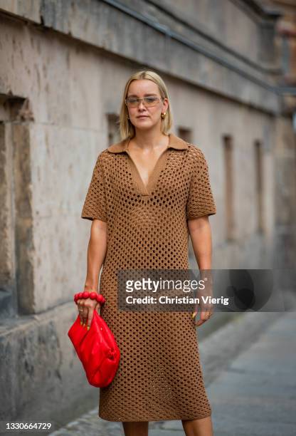 Tina Haase is seen wearing Chanel sunglasses, h&m crochet dress in brown, Essentiel Antwerp Bag in red, Zara heels on July 25, 2021 in Berlin,...