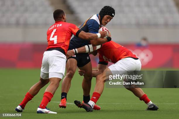 Masakatsu Hikosaka of Team Japan is tackled by Harry Glover and Dan Norton of Team Great Britain during the Men's Pool B Rugby Sevens match between...