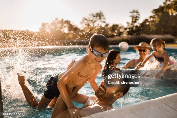 allegro padre e figlio che si divertono in piscina. - family pool foto e immagini stock