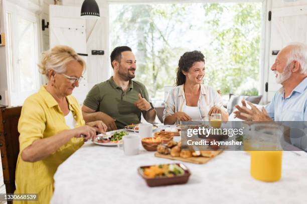 happy couple talking to senior couple during breakfast in dining room. - father in law stock pictures, royalty-free photos & images