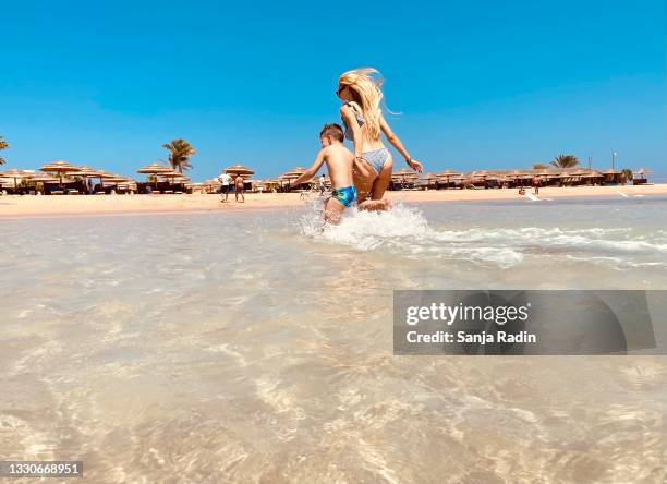 mother and her son jumping in water. - egyptian family imagens e fotografias de stock