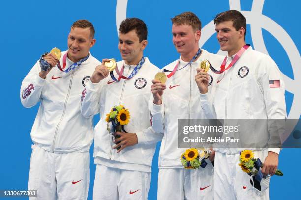 Caleb Dressel, Blake Pieroni, Bowen Becker and Zach Apple of Team United States look on during the medal ceremony after winning gold in the Men's...
