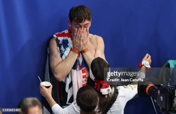 Tom Daley of Team Great Britain celebrates with friends winning the Gold Medal with Matty Lee following the Men's Synchronised 10m Platform Final on...