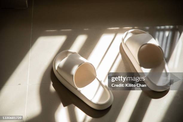 a pair of rubber slipper on the tile floor - materiale gommoso foto e immagini stock