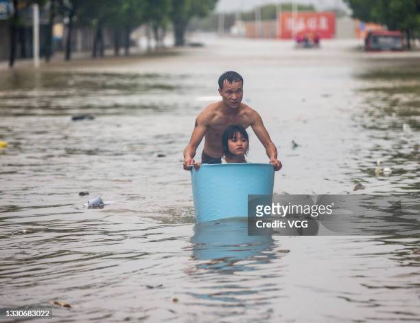 Local resident uses a bathtub to evacuate his relative from a flooded street on July 25, 2021 in Ningbo, Zhejiang Province of China. Typhoon In-Fa...