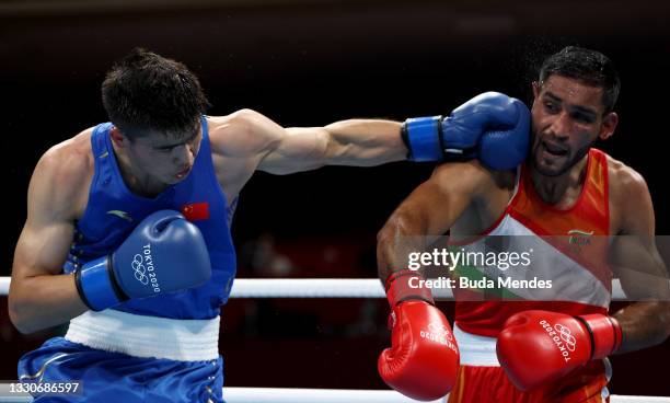 Ashish Kumar of India exchanges punches with Erbieke Tuoheta of China during the Men's Middle on day three of the Tokyo 2020 Olympic Games at...