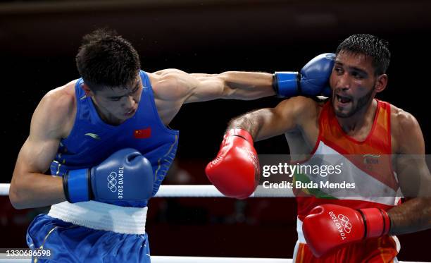 Ashish Kumar of India exchanges punches with Erbieke Tuoheta of China during the Men's Middle on day three of the Tokyo 2020 Olympic Games at...