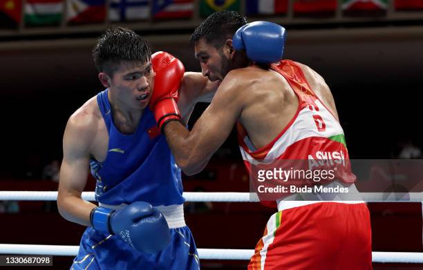 Ashish Kumar of India exchanges punches with Erbieke Tuoheta of China during the Men's Middle on day three of the Tokyo 2020 Olympic Games at...