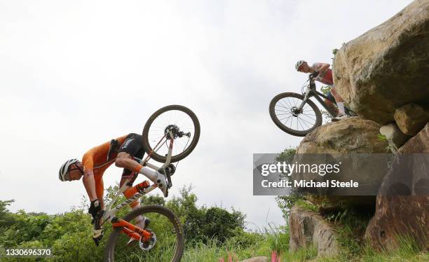 Mathieu van der Poel of Team Netherlands suffers a fall ahead of Thomas Pidcock of Team Great Britain during the Men's Cross-country race on day...