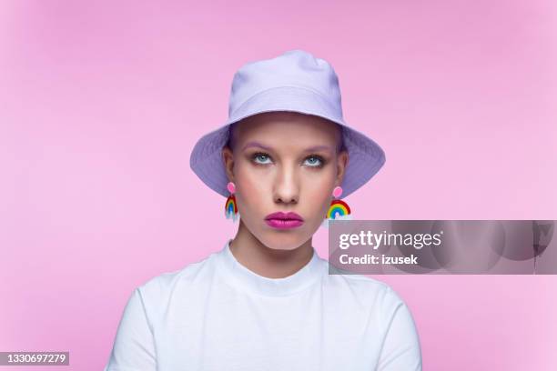 headshot of woman with rainbow earrings - bucket hat stock pictures, royalty-free photos & images