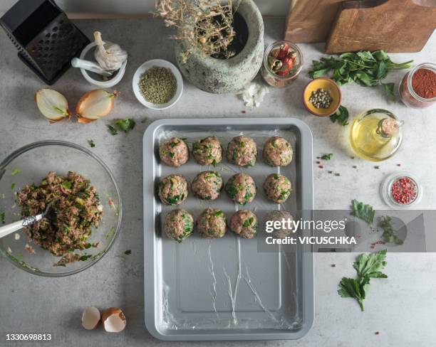 meatballs cooking preparation on light grey concrete kitchen table with ingredients and kitchen utensils - meatball stock pictures, royalty-free photos & images