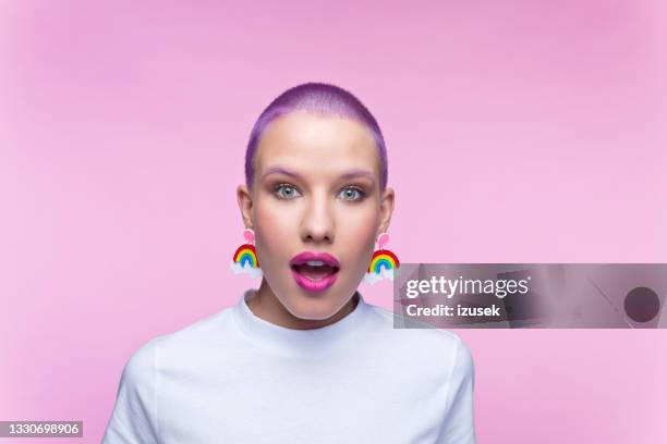 headshot of woman with short purple hair and rainbow earrings - sem palavras imagens e fotografias de stock