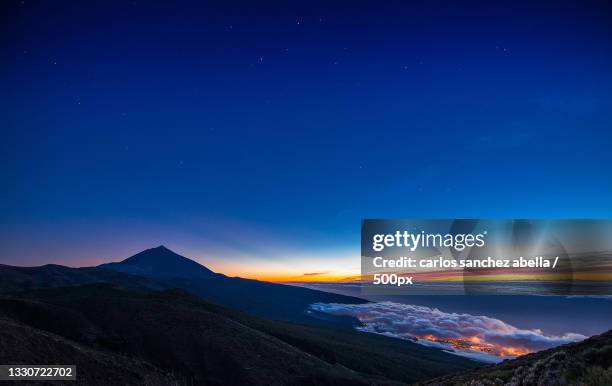 scenic view of mountains against blue sky at night,parque nacional del teide,santa cruz de tenerife,spain - abella stock pictures, royalty-free photos & images