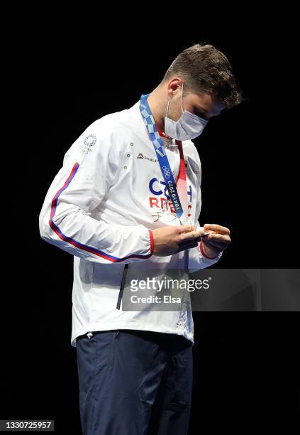 Bronze medalist Alexander Choupenitch of Team Czech Republic looks at his medal on the podium during the medal ceremony for Men's Foil Individual...