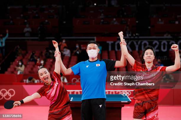 Ito Mima and Jun Mizutani of Team Japan celebrate with their coach after winning their Mixed Doubles Gold Medal match on day three of the Tokyo 2020...
