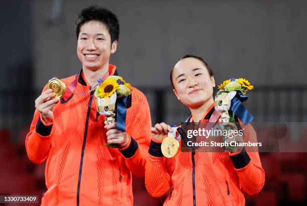 Ito Mima and Jun Mizutani and Ito Mima of Team Japan pose with their medals after winning their Mixed Doubles Gold Medal match on day three of the...