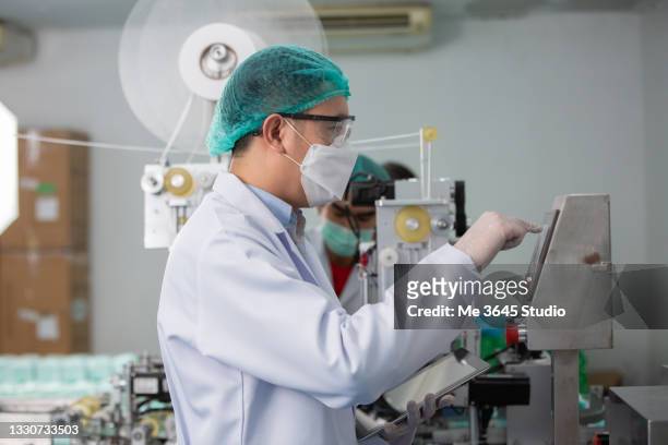 robotics are transforming industries, asian engineering man in control room ,mask factory production - doctor and engineer stock pictures, royalty-free photos & images