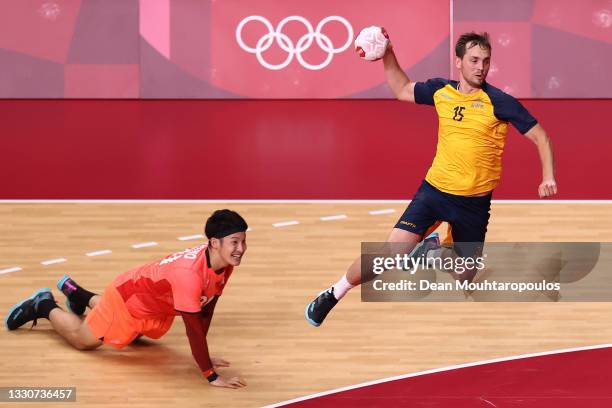 Hampus Wanne of Team Sweden shoots at goal as Tatsuki Yoshino of Team Japan looks on after falling during the Men's Preliminary Round Group B match...