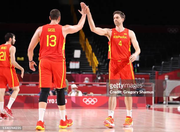 Pau Gasol of Team Spain high fives his brother Marc Gasol during the first half of the Men's Preliminary Round Group C game on day three of the Tokyo...