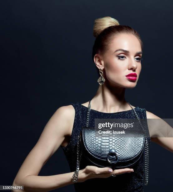 portrait of elegant woman holding evening bag - purse stock pictures, royalty-free photos & images