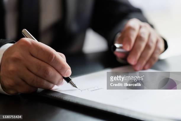 geschäftsmann unterzeichnet vertrag im büro - hand pen stock-fotos und bilder