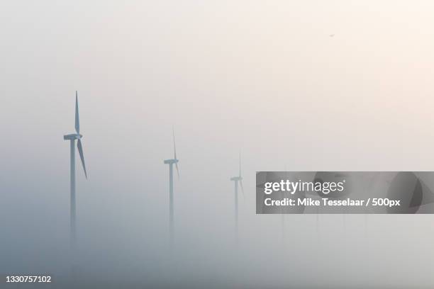 scenic view of windmills against sky during foggy weather,burgervlotbrug,netherlands - new discovery stock pictures, royalty-free photos & images