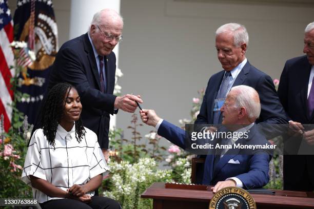 President Joe Biden gives a pen to Sen. Pat Leahy after signing a proclamation on the anniversary of the Americans with Disabilities Act in the Rose...