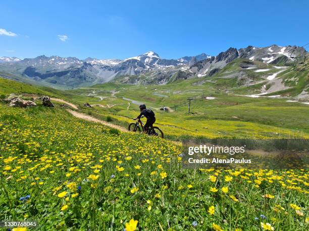 woman riding a bike downhill in tignes bike park in france - alpen sommer stock pictures, royalty-free photos & images