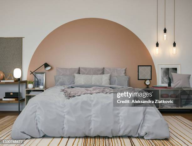 comfortable bedroom with painted arch headboard - beige bedroom stock pictures, royalty-free photos & images