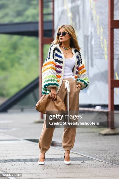 Influencer Gitta Banko wearing slouchy camel colored pants by R13, an oversized white knitted cardigan with multicolored stripes by Maiami, white...