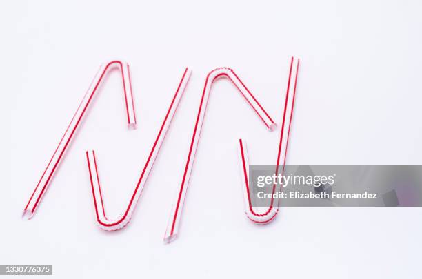 high angle view of four drinking straws on white background - red straw stock pictures, royalty-free photos & images
